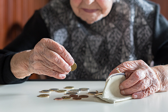 Une dame âgée comptant des pièces.