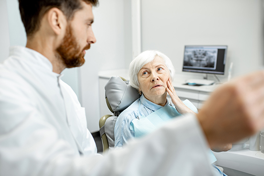 Une dame ayant une consultation avec un dentiste.