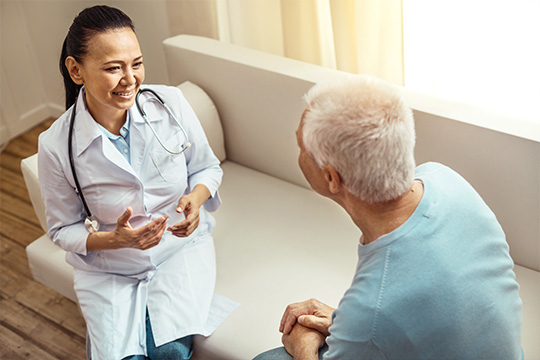 Un homme ayant une conversation avec son médecin sur un canapé Homme ayant une conversation à déprescription avec un médecin