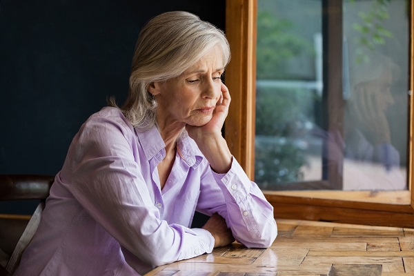 A woman sitting at a table staring thoughtfully downward Federal Retirees advocates for fair pensions
