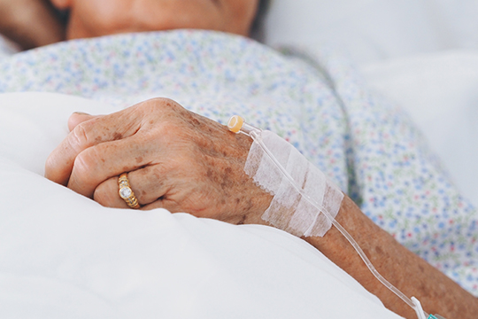 Canadians deserve better long-term care. A senior's hand in hospital setting.