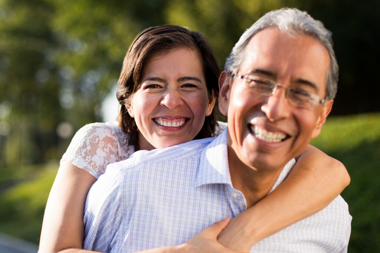 Adultes heureux et souriants à l'extérieur.