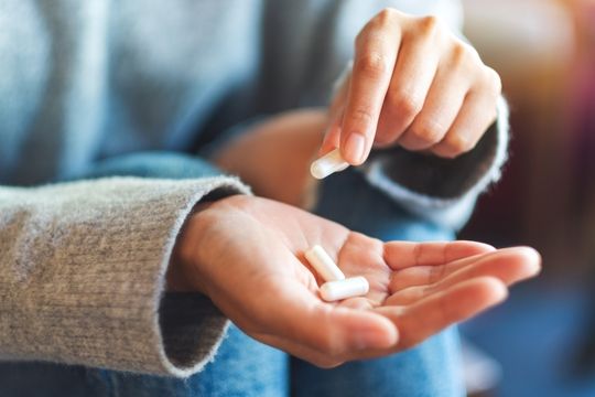 Adult woman holding medication.