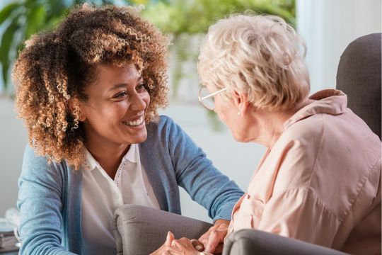 Femme avec une proche aidante souriante.