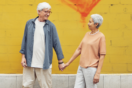 A senior couple holding hands.