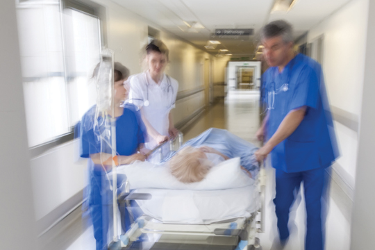 Médecins poussant un patient dans un couloir.