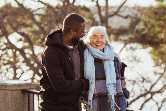 Il est temps de remédier aux soins de longue durée au Canada. Homme adulte soignant une patiente à l’extérieur.