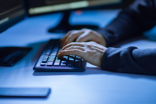 Close up of hands at a computer.