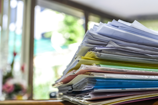 Qu’arrive-t-il au surplus de la Caisse de retraite de la fonction publique? Pile de factures et de documents sur un bureau.