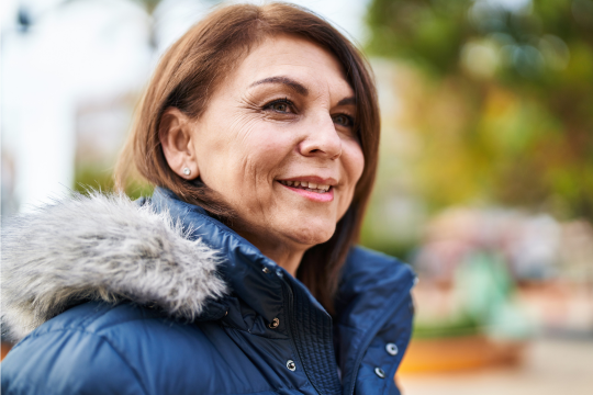 Agissez, en devenant agent·e des programmes de défense des intérêts! Femme adulte souriante, portant un manteau d’hiver.