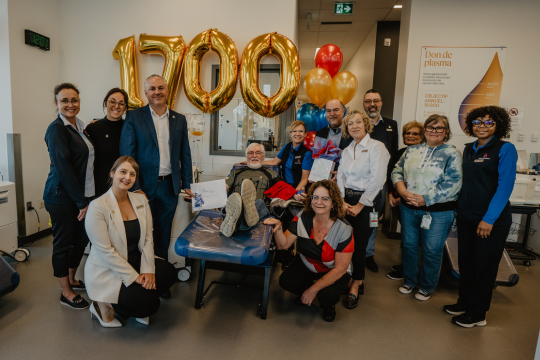 Un groupe de personnes célébrant l’étape importante du don de sang de Jean Bernier.