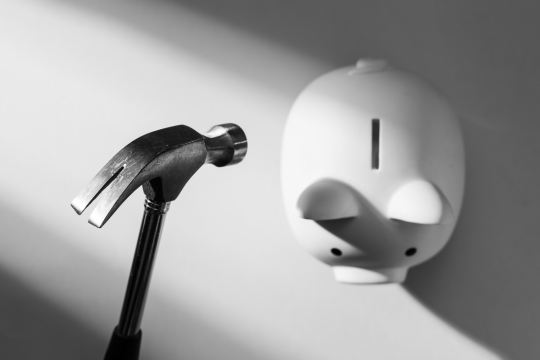 Marteau sur le point de briser une tirelire.