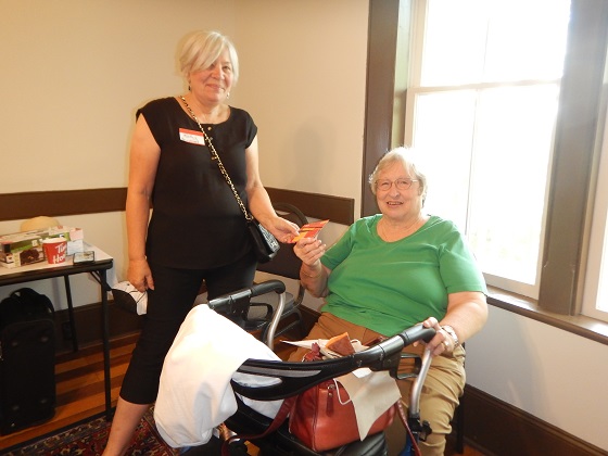 Kathy Rupnow (standing) with Donna Wallace (sitting) and presenting her with the door price.