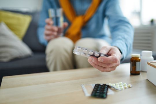 Homme adulte avec plusieurs médicaments.