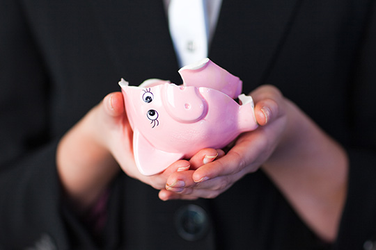 hands holding a broken piggy bank