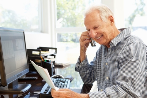 Un homme sur un téléphone en face de l'ordinateur de bureau. Un homme sur un téléphone en face de l'ordinateur de bureau.