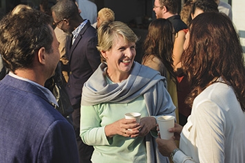 A woman shaking hands with another woman and a man who is part of their conversation People shaking hands while networking with the Federal Retirees community