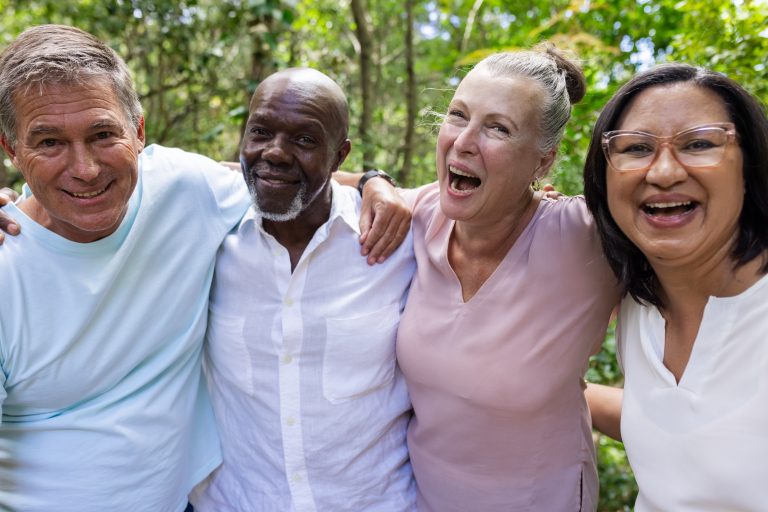 Groupe de personnes âgées souriantes se tenant debout ensemble.