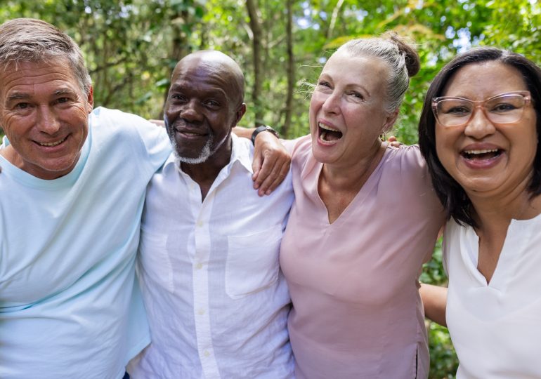 Groupe de personnes âgées souriantes se tenant debout ensemble.