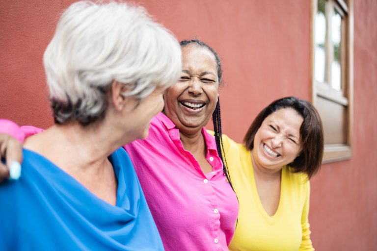 Three adult women friends standing together.