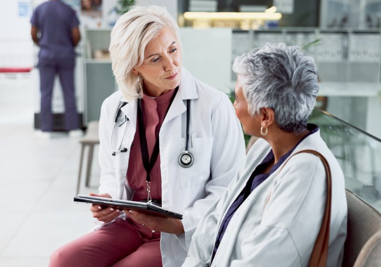 Patient adulte en consultation avec un médecin dans un milieu hospitalier.