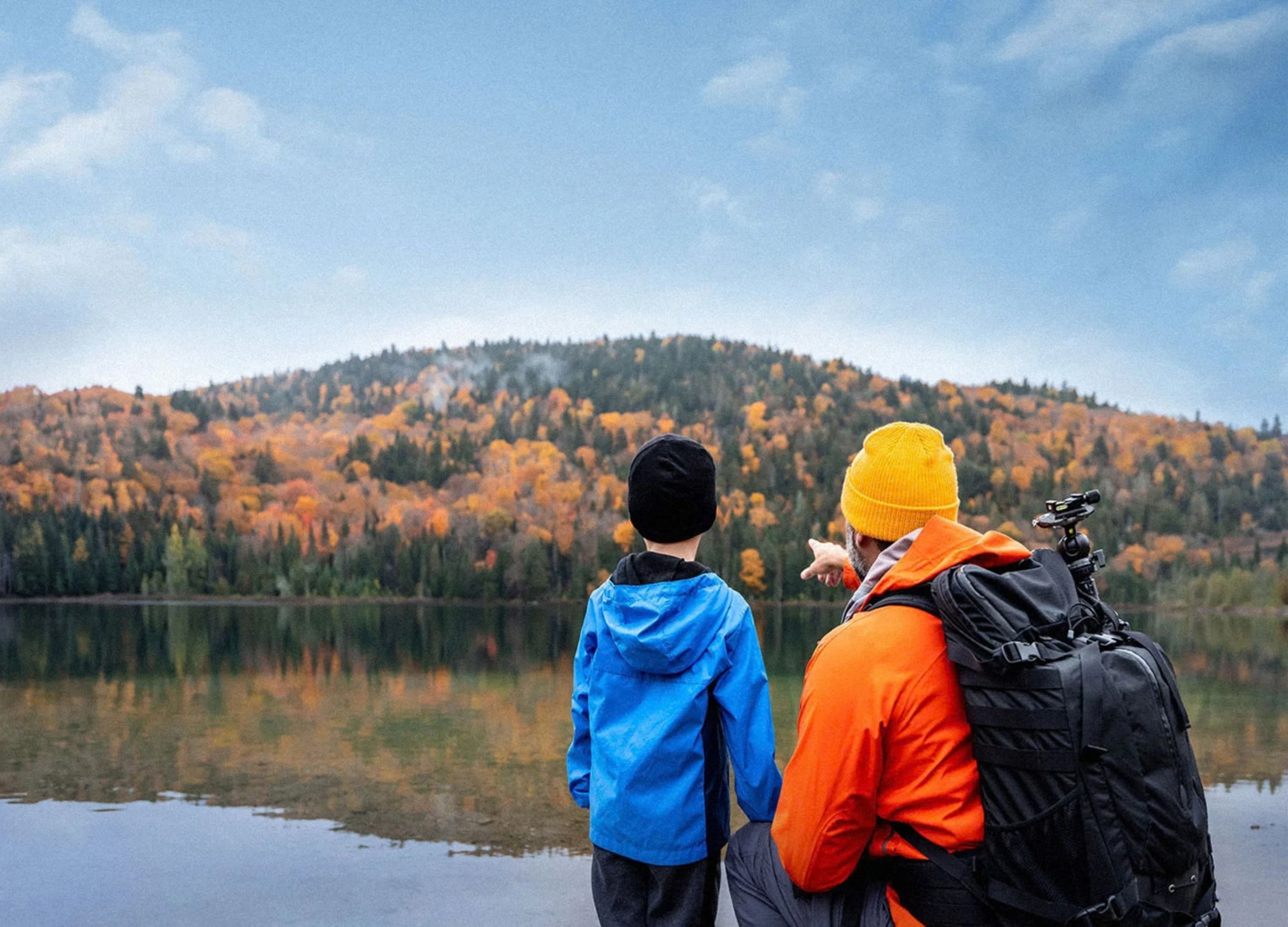 Un père et son fils regardent un lac.